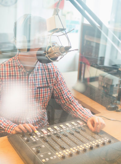 Homme derrière une table de mixage à la radio